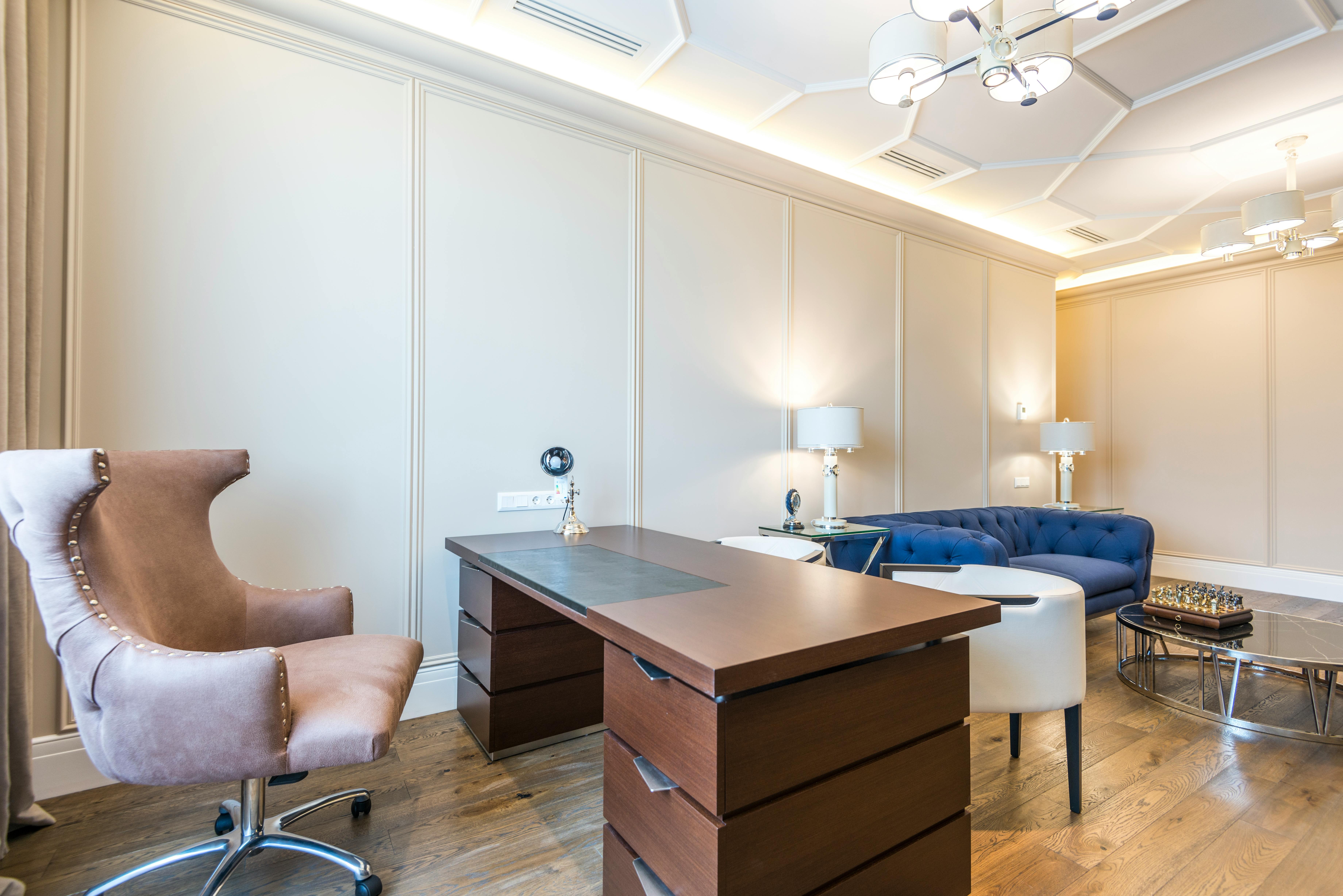 A modern office featuring a sleek desk, ergonomic chair, and a comfortable couch for relaxation